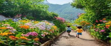 广州白云山野花步道，五颜六色的野花沿山路盛开，孩子在花丛中奔跑嬉戏，绿意盎然生机勃勃